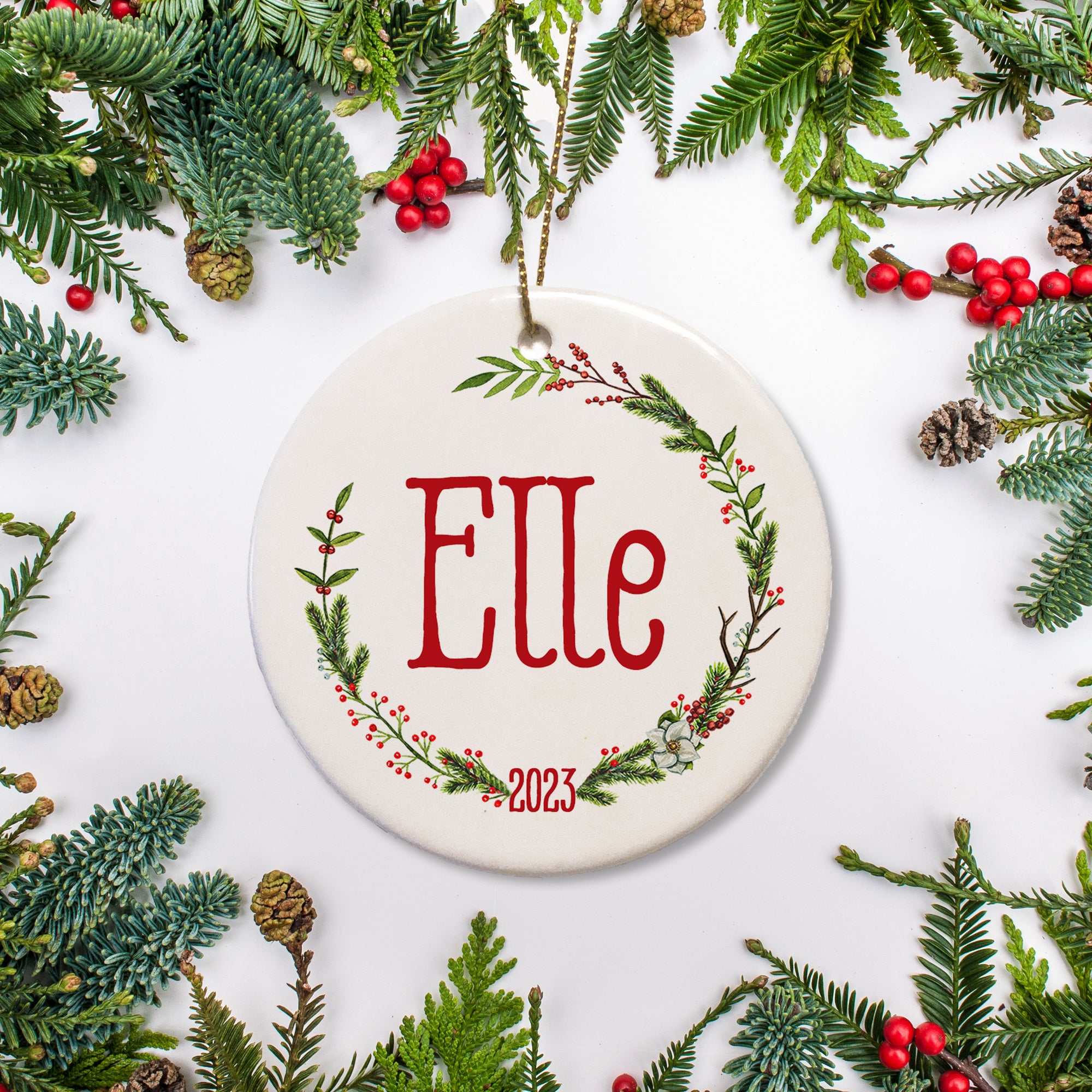 Personalized Christmas ornament with a holiday open wreath. Name written in big red letters and the year featured at the bottom of the wreath. Add name and year of your choice