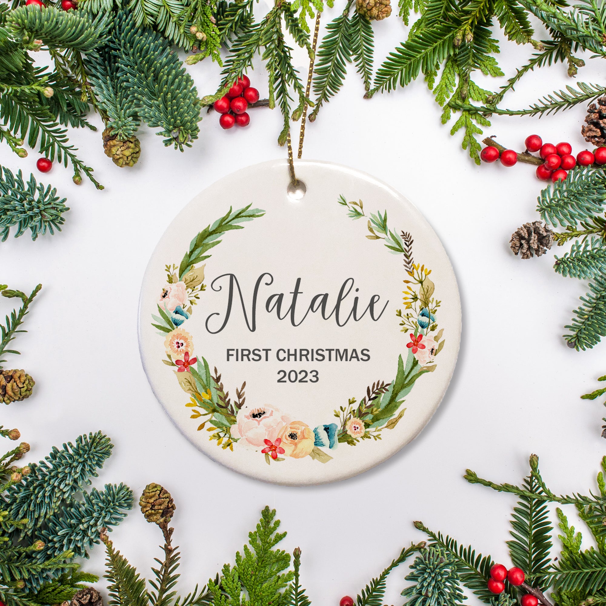 Personalized Christmas Ornament with name and year of your choice for baby's first Christmas, surrounded by olive wreath with blossom flowers throughout. | PIPSY.COM