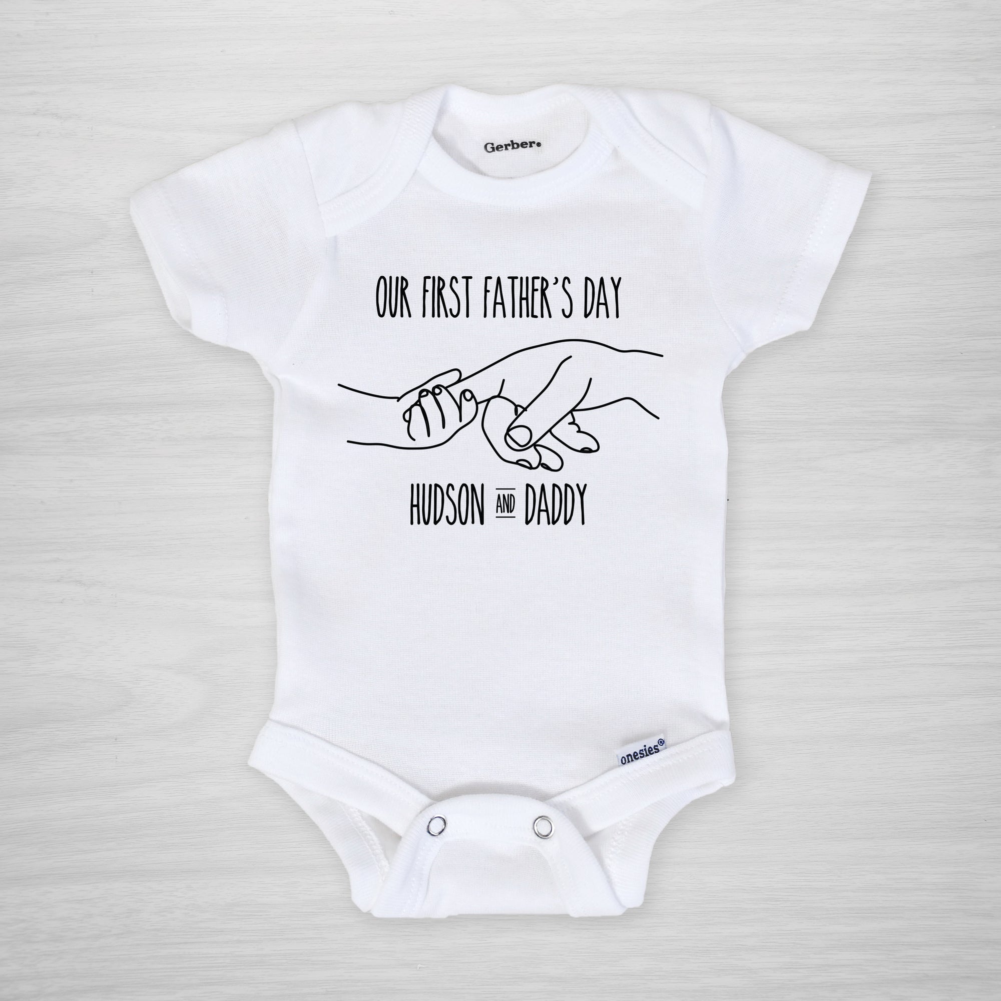 Father's Day Onesie, depicting father and child holding hands, personalized with your baby's name, short sleeved