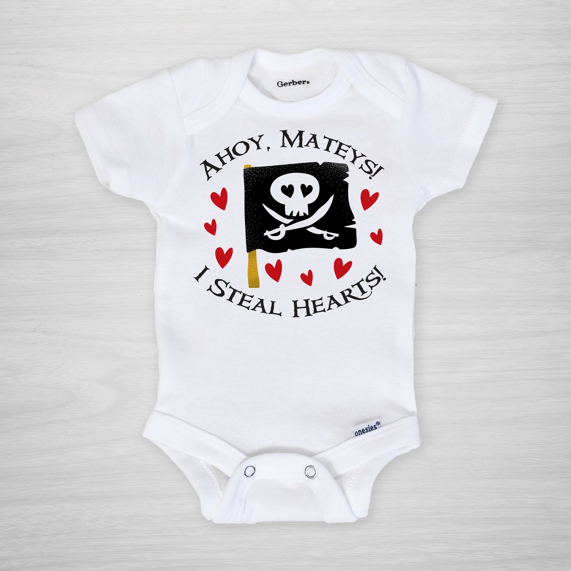Pirate onesie for Valentine's Day. A cute pirate flag, with text that reads "Ahoy Mateys! I steal hearts!"  Printed on a genuine Gerber onesie® and hand pressed in Pipsy's Nashville studio, long sleeved