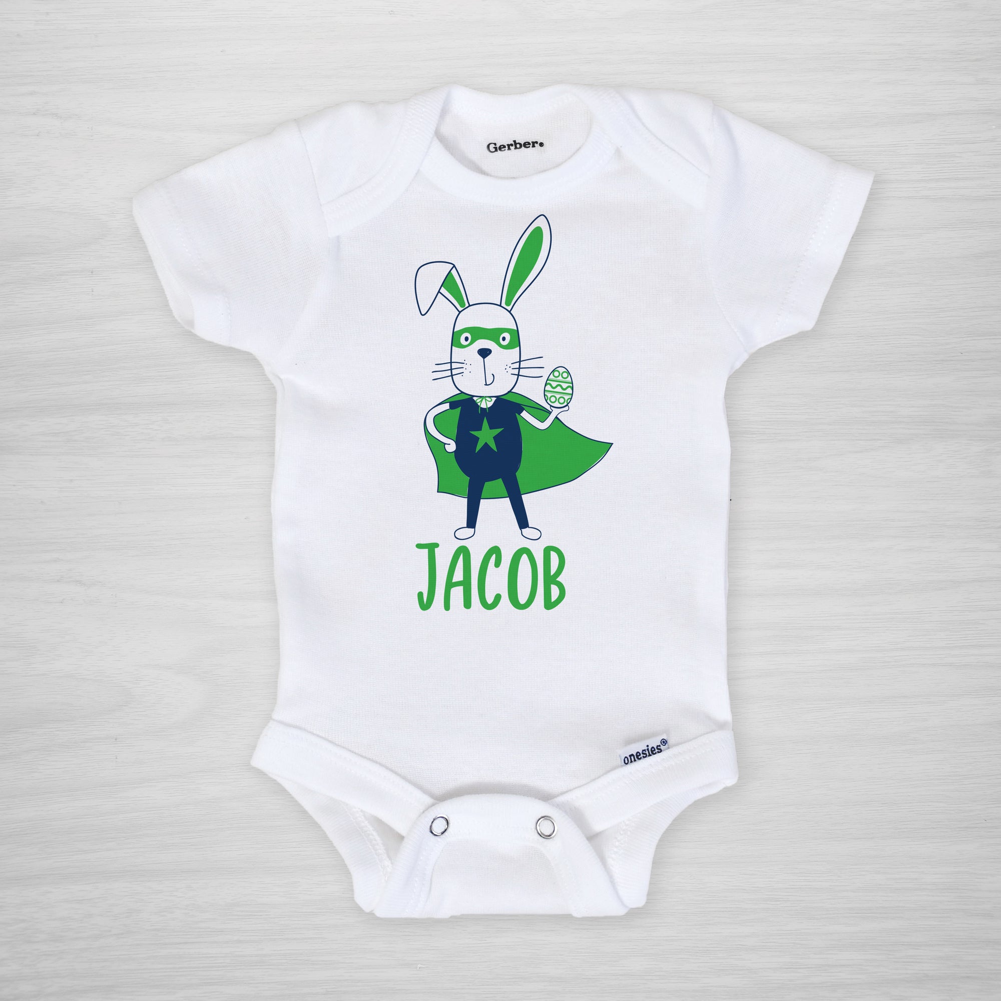 Superhero Easter Bunny with a cape, mask, and egg on this personalized Gerber Onesie®, short sleeved blue