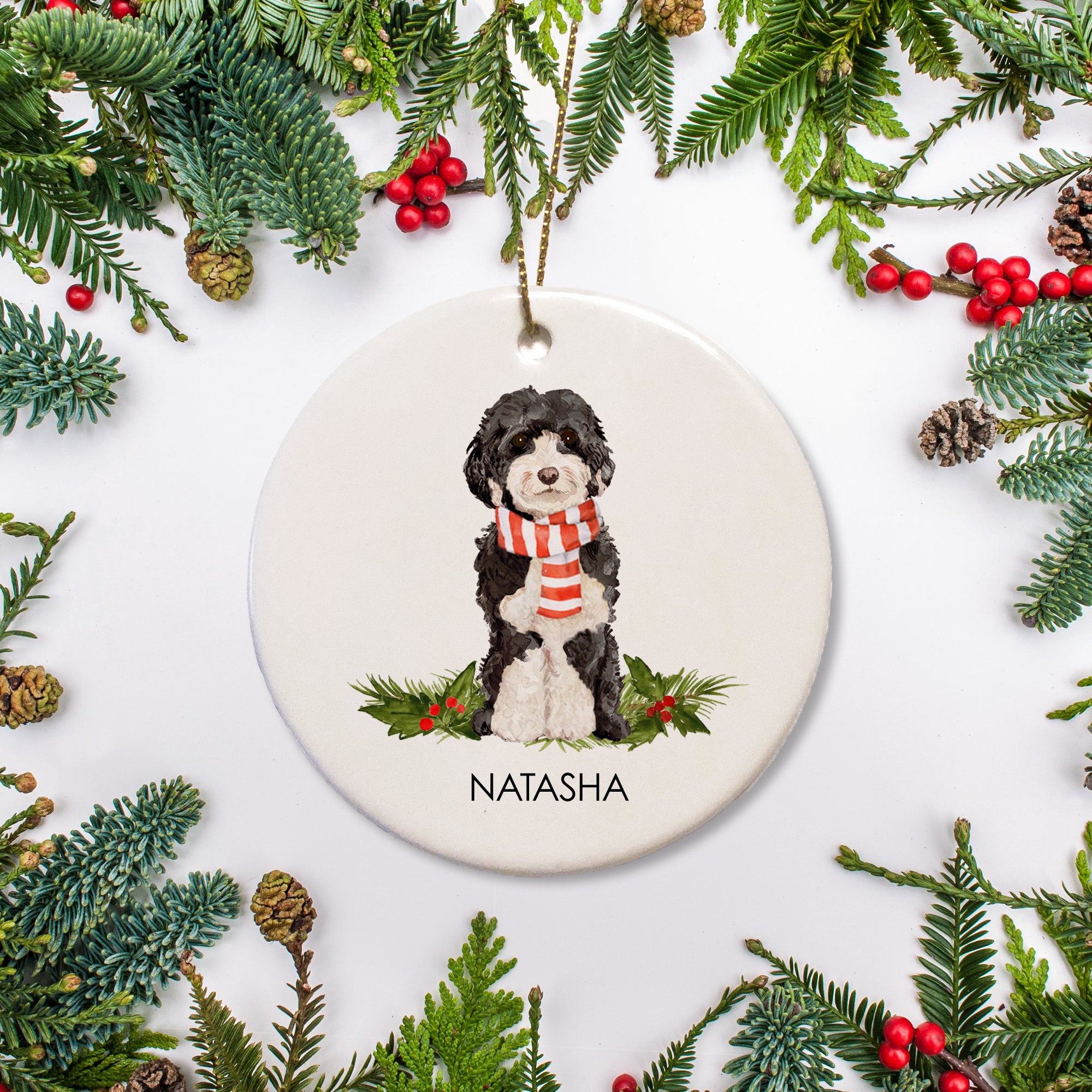 Cockapoo christmas ornament, featuring a black and white dog in a holiday scart. Personalized with your pet's name and crafted of ceramic