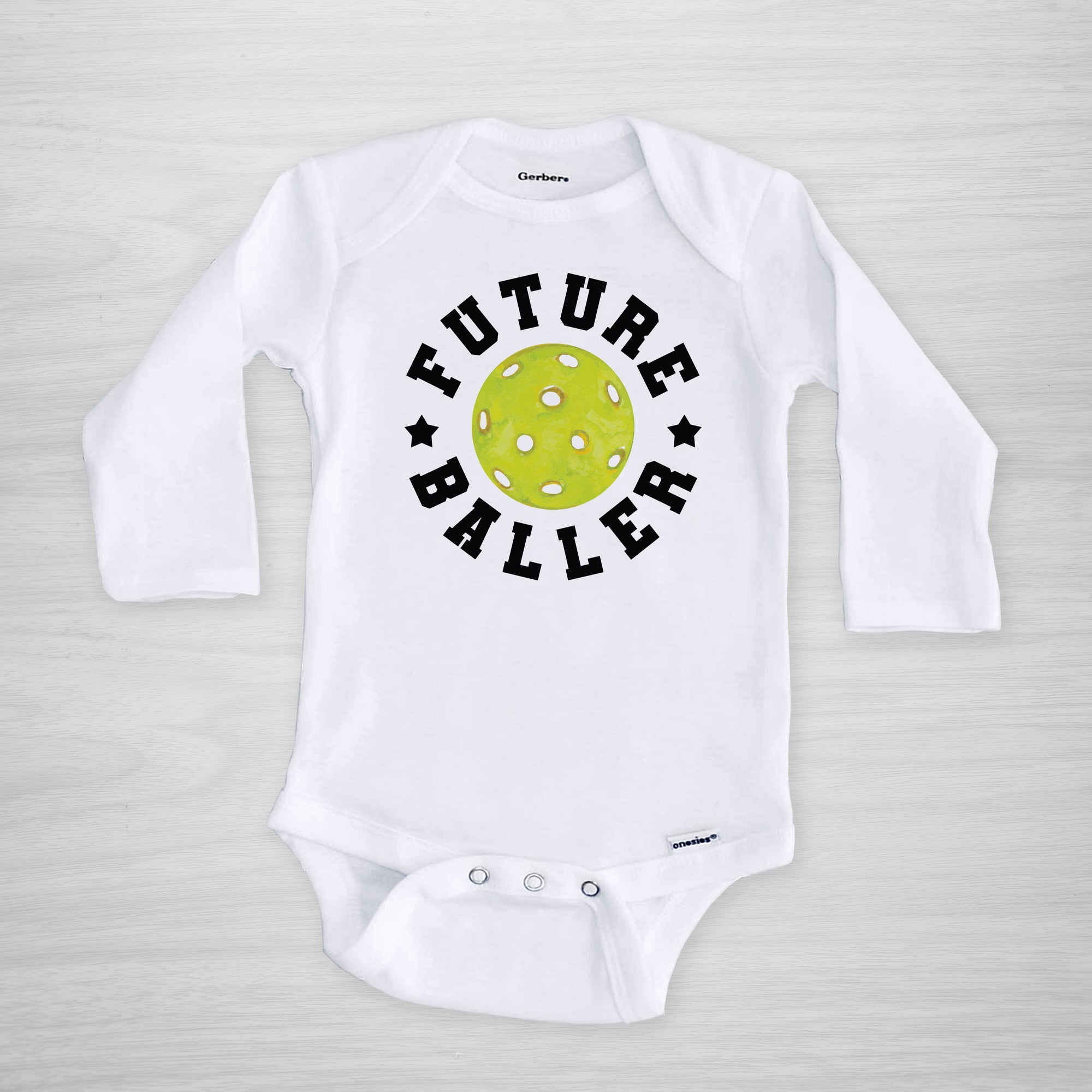 Future Baller Pickleball Gerber Onesie®. You can leave a note and specify team colors for the text. Otherwise, the print will be black as shown. Makes a great baby shower gift for your favorite picklehead.