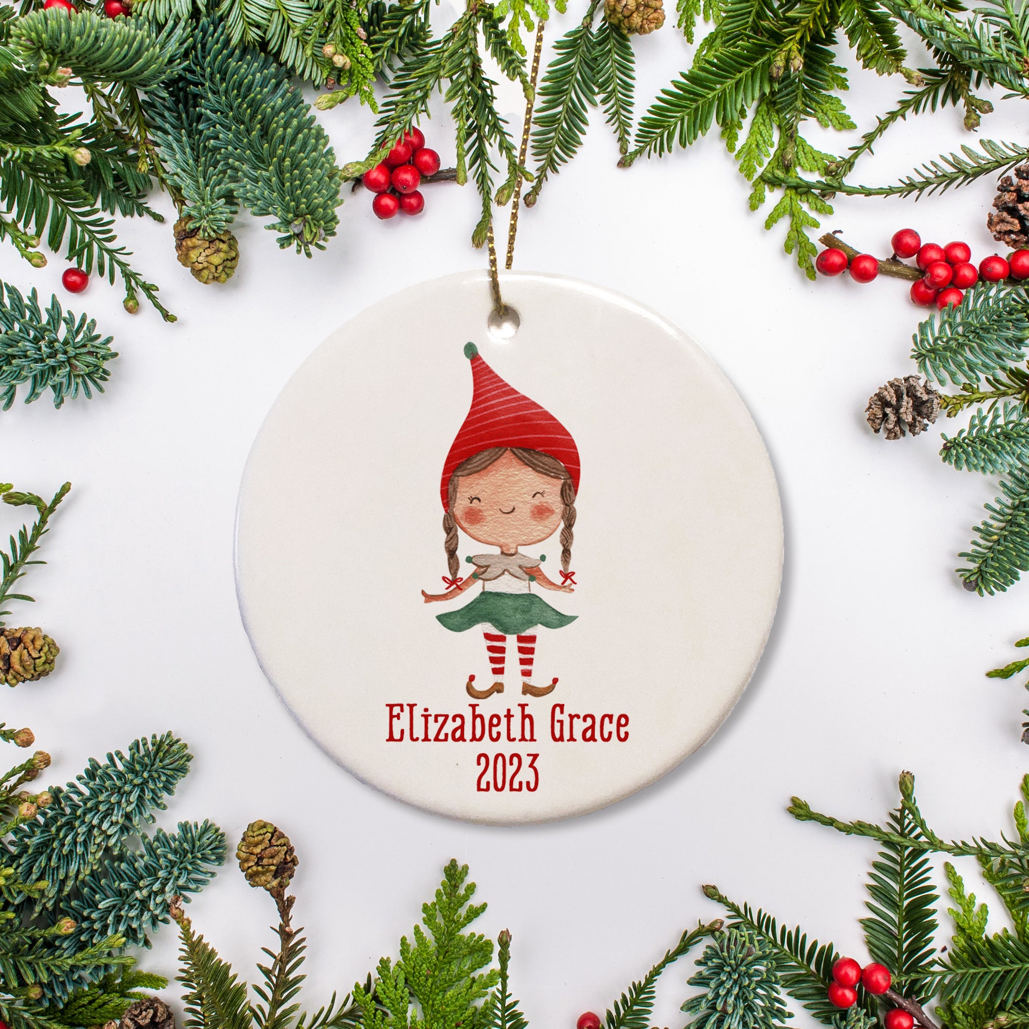 A sweet girl elf picture on a ceramic ornament with the name and the date.