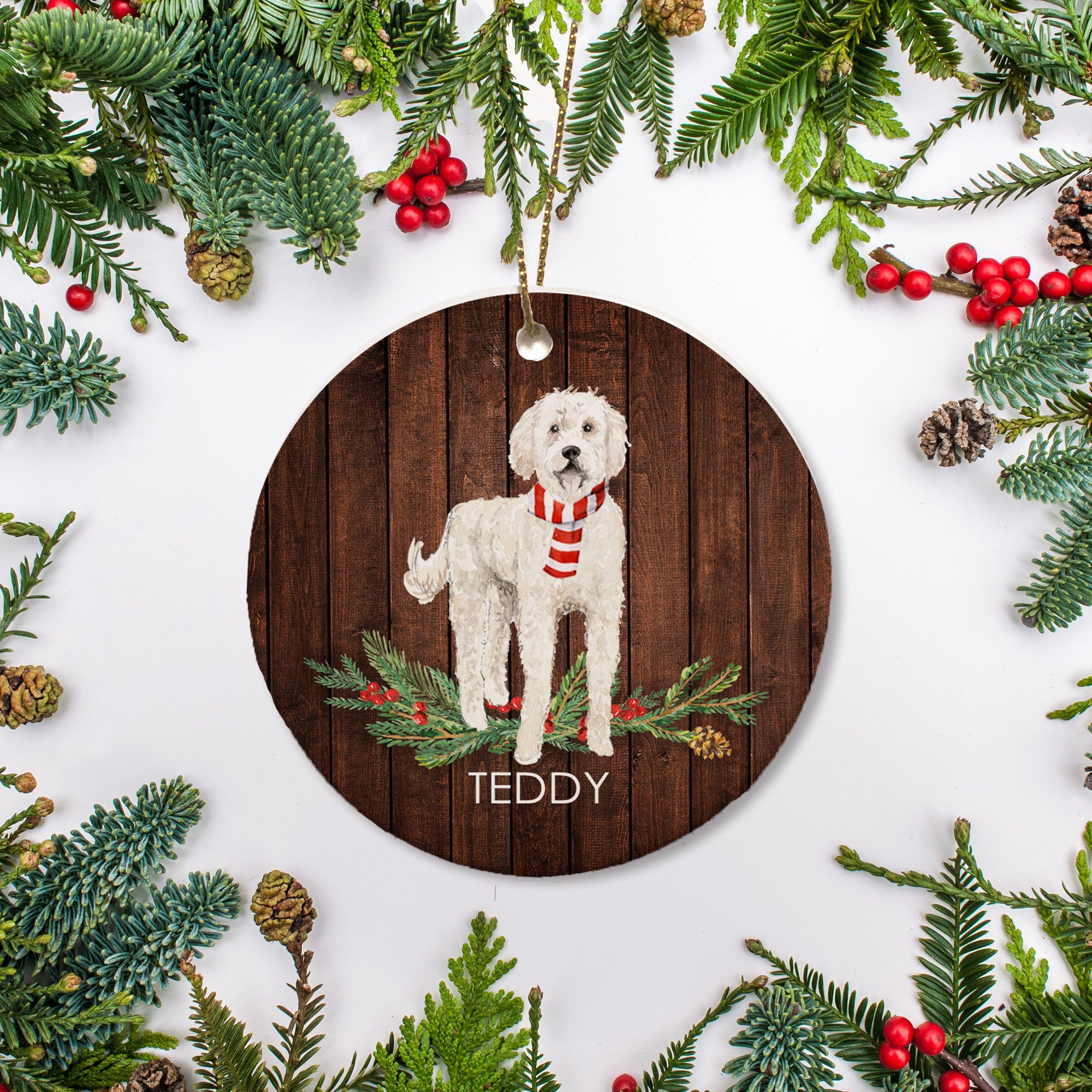 White Goldendoodle Christmas ornament standing on a patch of pine needles and berries. Personalize with the name and year of your choice. | PIPSY.COM