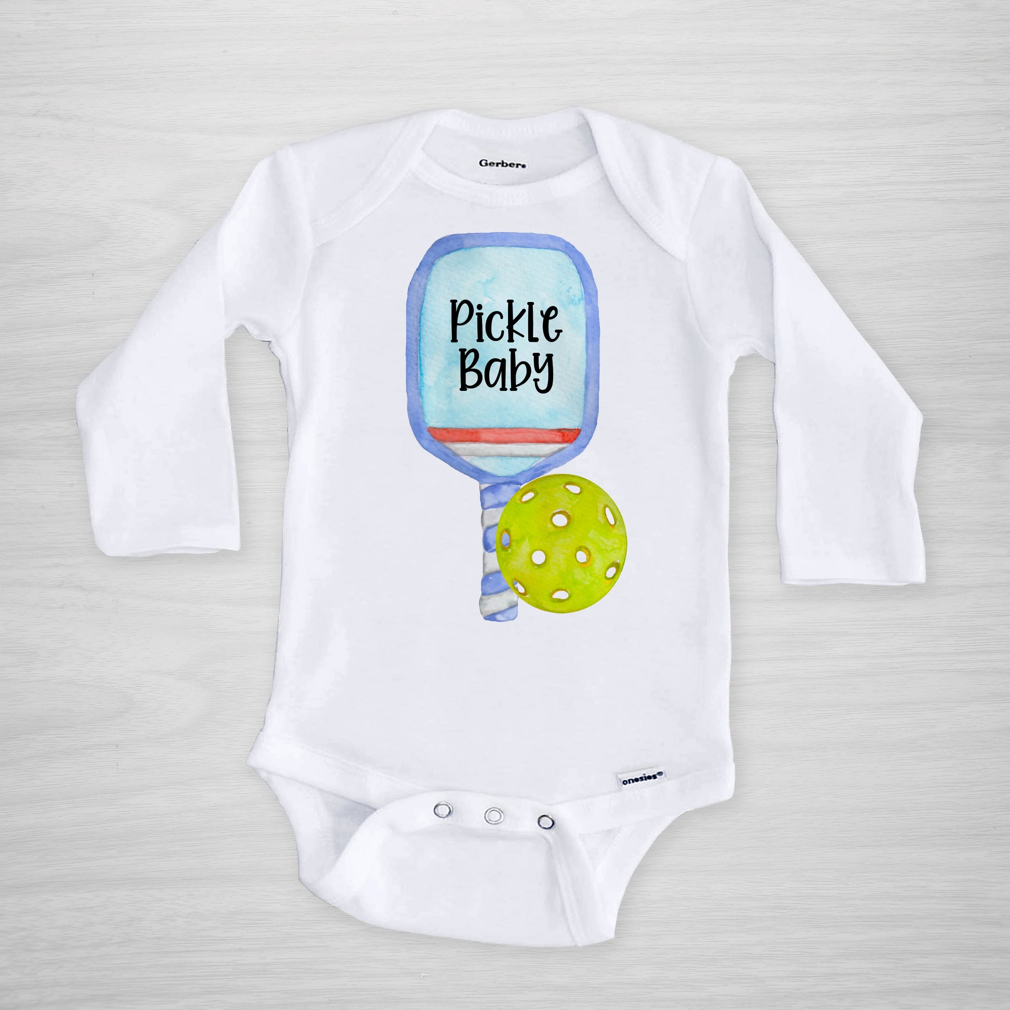 Pickleball Gerber Onesie® with a blue paddle. You can leave a note and specify team colors for the text. Otherwise, the print will be black as shown. Makes a great shower gift for the new pickle baby