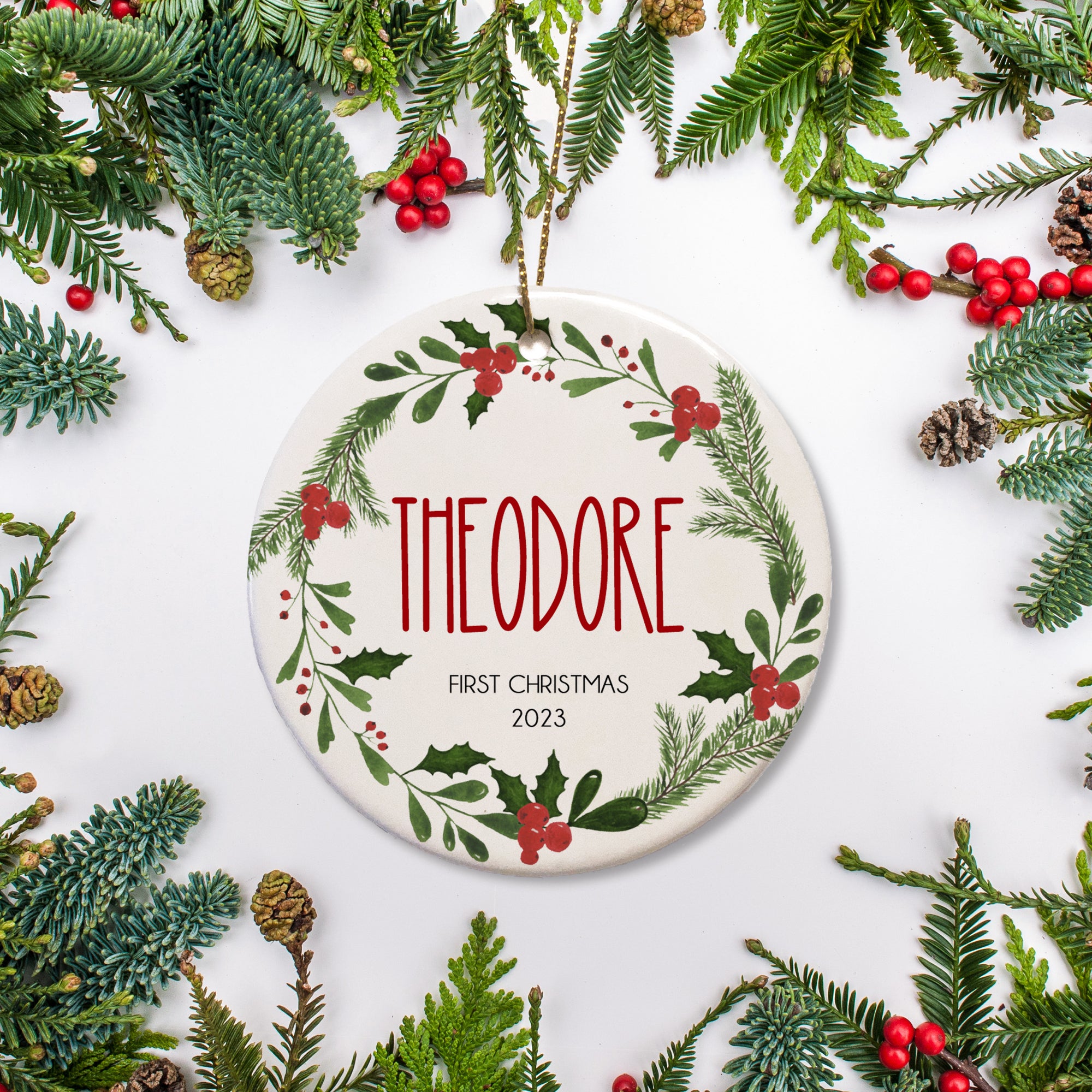Baby's first Christmas personalized Ornament. Name and year of your choice in the center of a holly and pine wreath. | PIPSY.COM