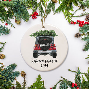A keepsake ornament of a jeep which says “Engaged” with a Christmas tree which is personalized and includes the year. The jeep is red.