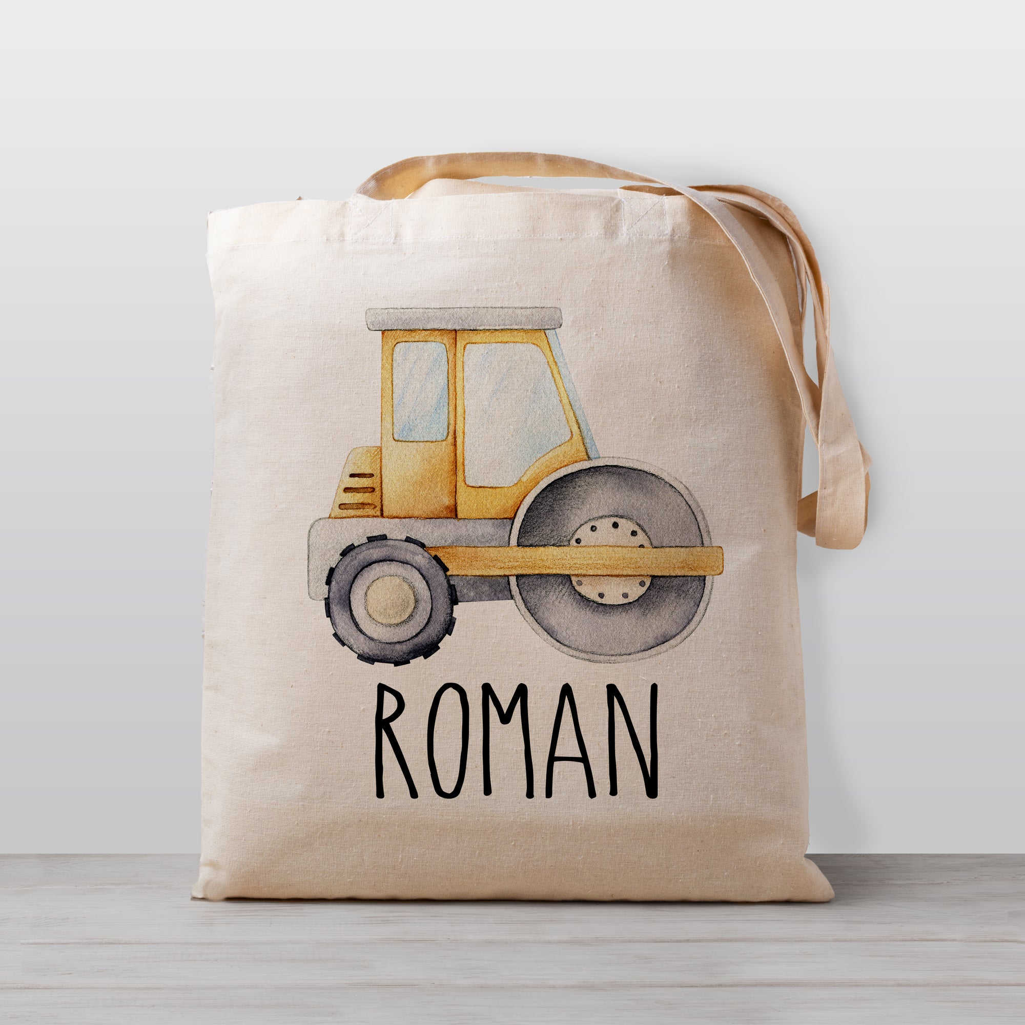 A cute personalized roller compactor construction tote bag, perfect for carrying your little one's stuff to preschool, kindergarten, or to use as a library book bag.