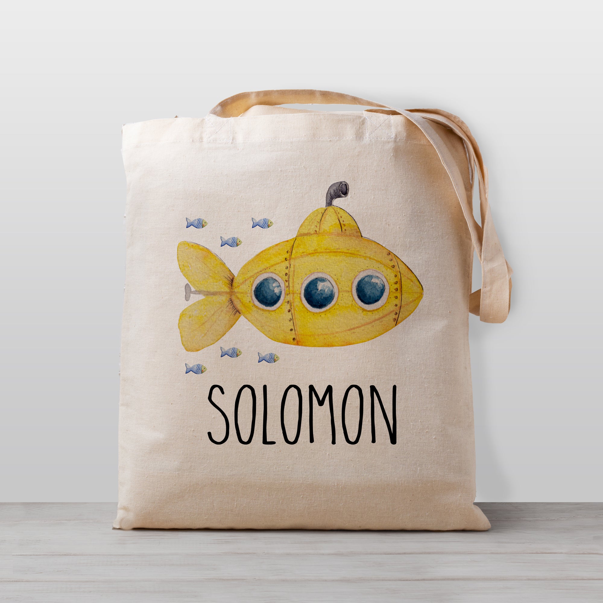 A submarine personalized tote bag, perfect for carrying your little one's stuff to preschool or kindergarten. This under the sea design even includes some cute fish following behind. Works great as a library book bag, too! 