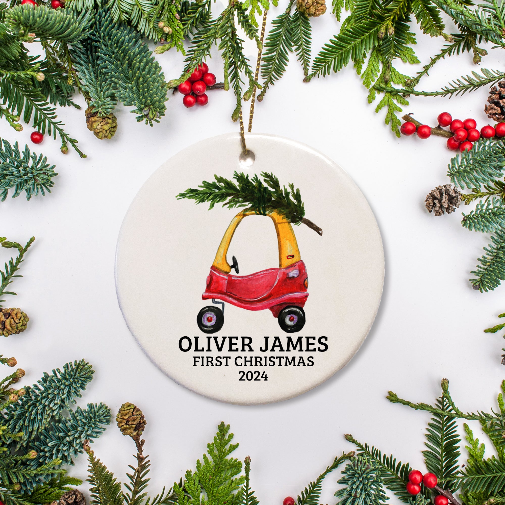 A toddler's  red and yellor car personalized on a ceramic ornament with a Christmas tree. This is a keepsake.