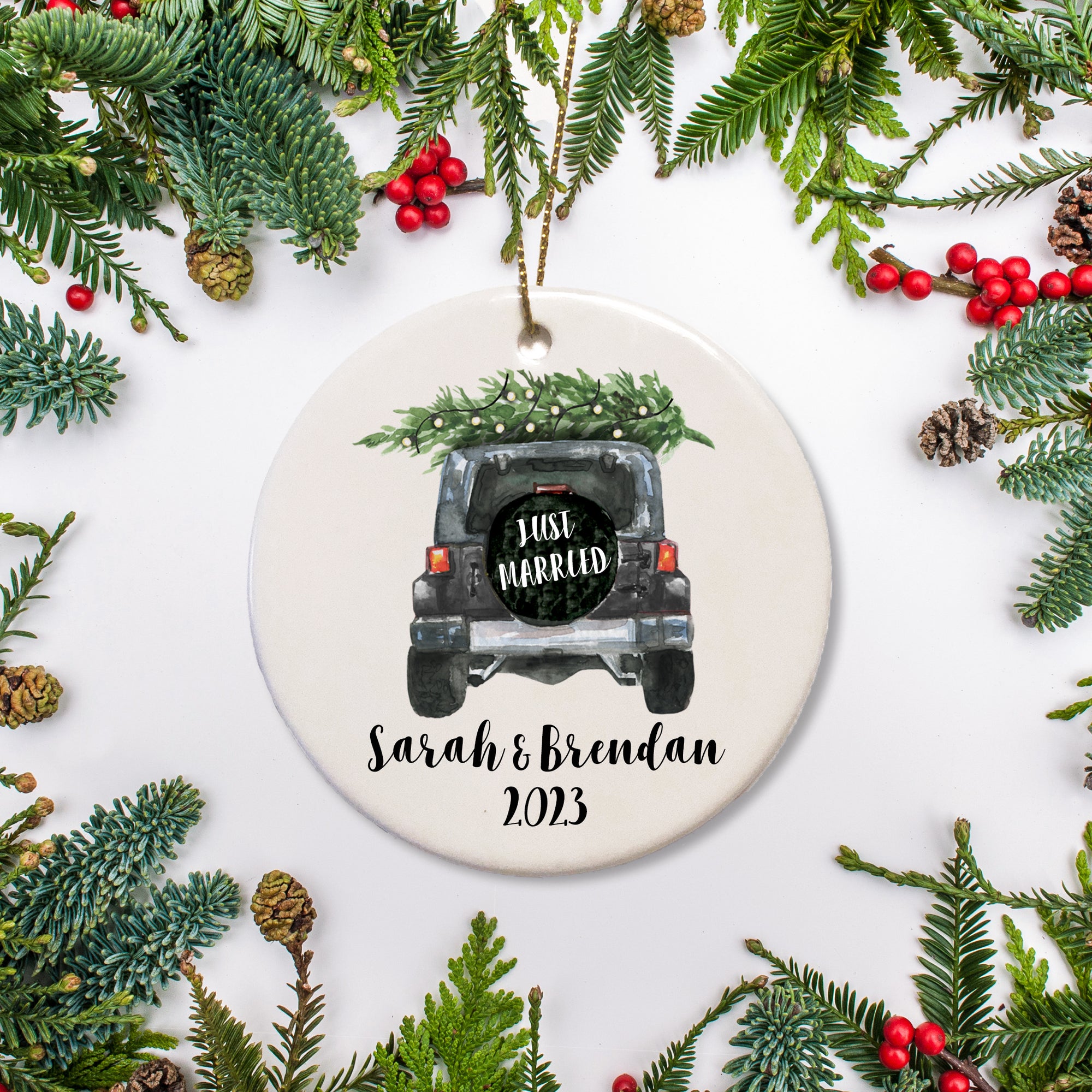 A keepsake ornament of a jeep which says “Just Married” with a Christmas tree which is personalized and includes the year. The jeep is black