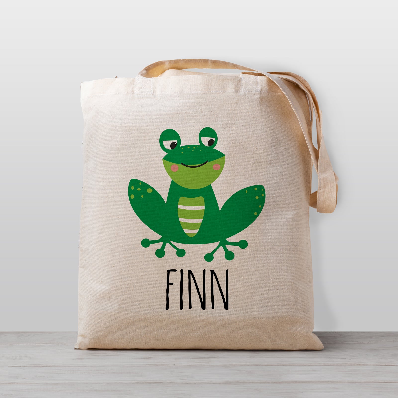 A cute personalized frog tote bag, perfect for carrying your little's stuff to daycare, preschool, or to use as a library book bag. Gender neutral so it's perfect for a boy or girl.
