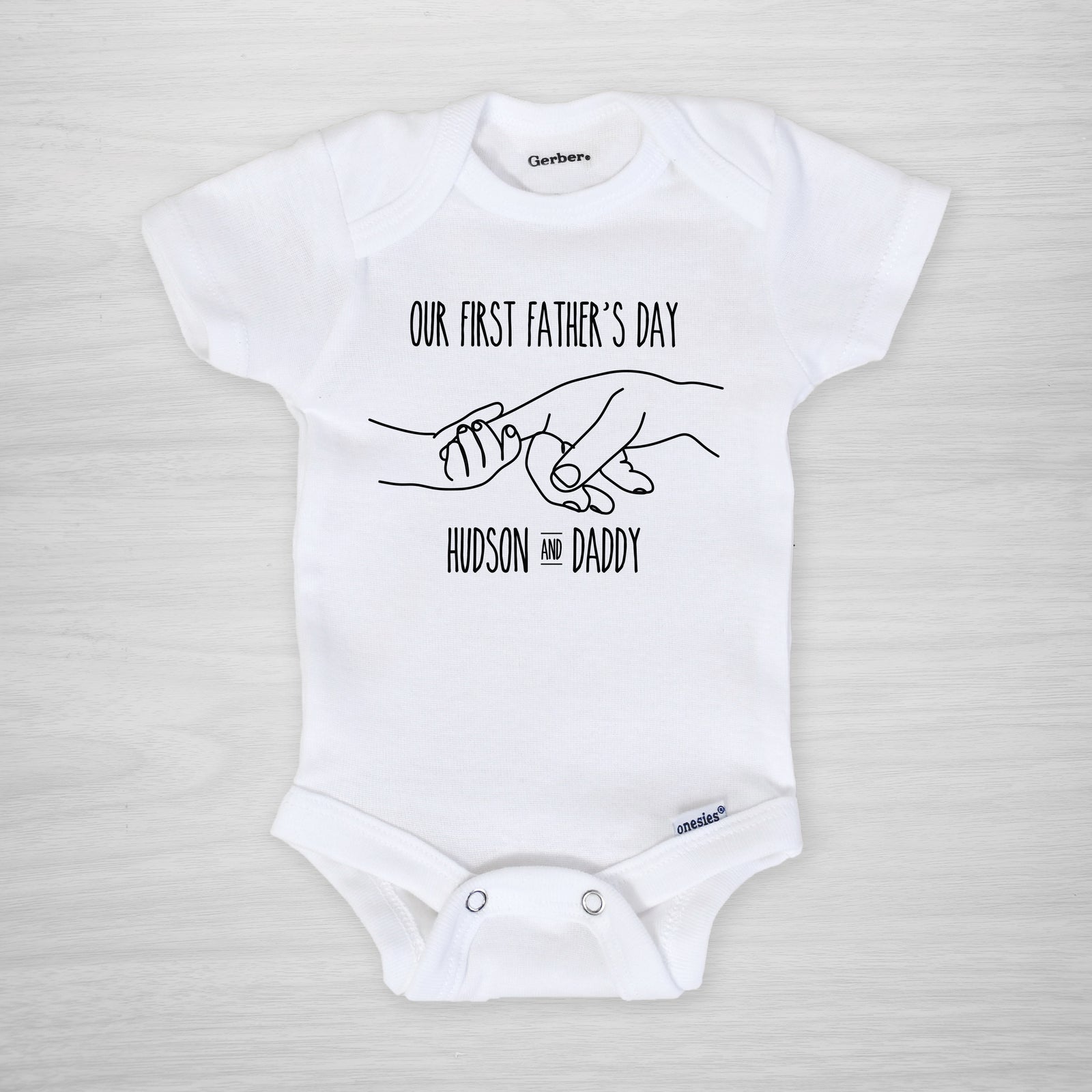 Father's Day Onesie, depicting father and child holding hands, personalized with your baby's name, short sleeved
