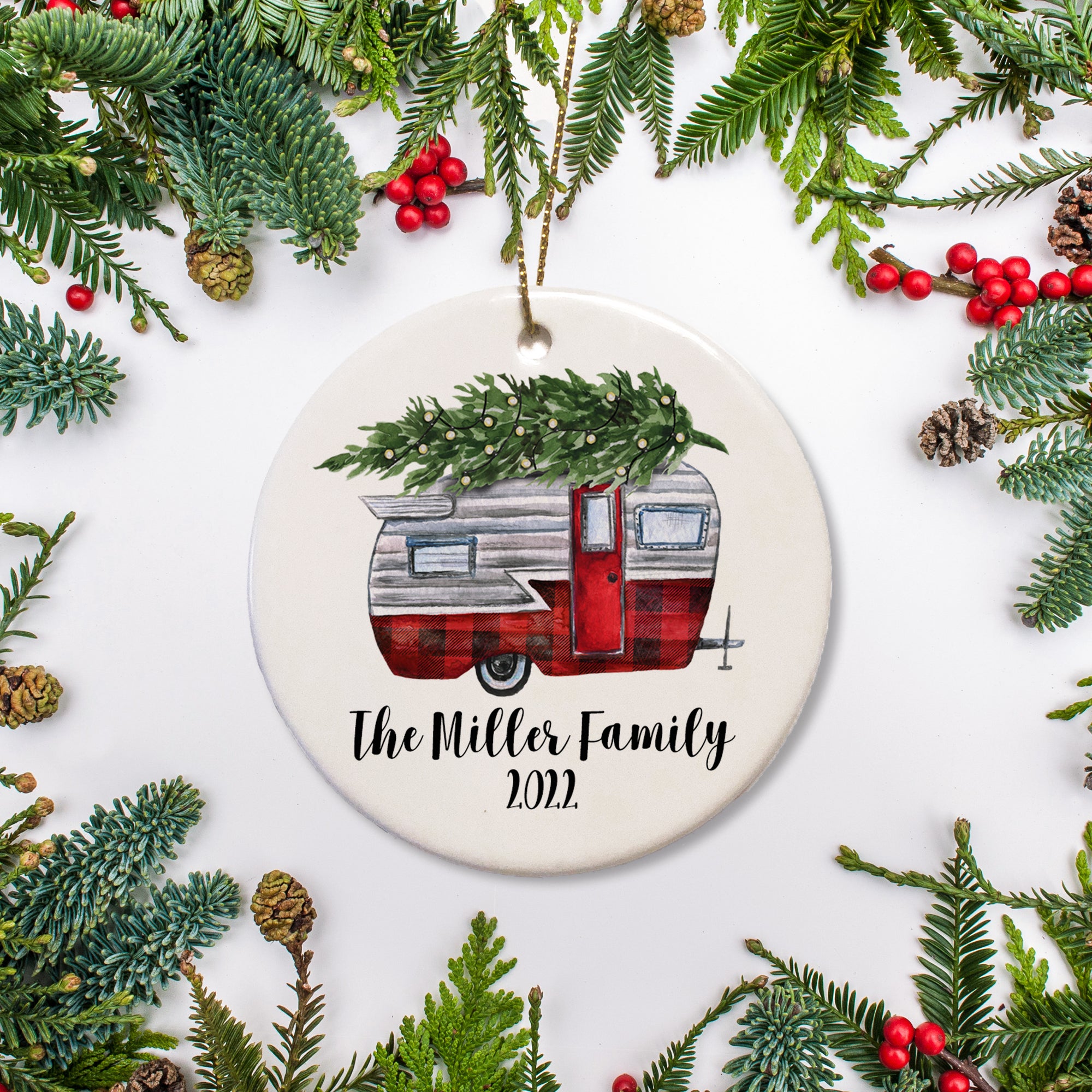 Personalized Christmas ornament with classic camper carrying a Christmas tree. Buffalo plaid and silver colors. Add family name and year of your choice. PIPSY.COM