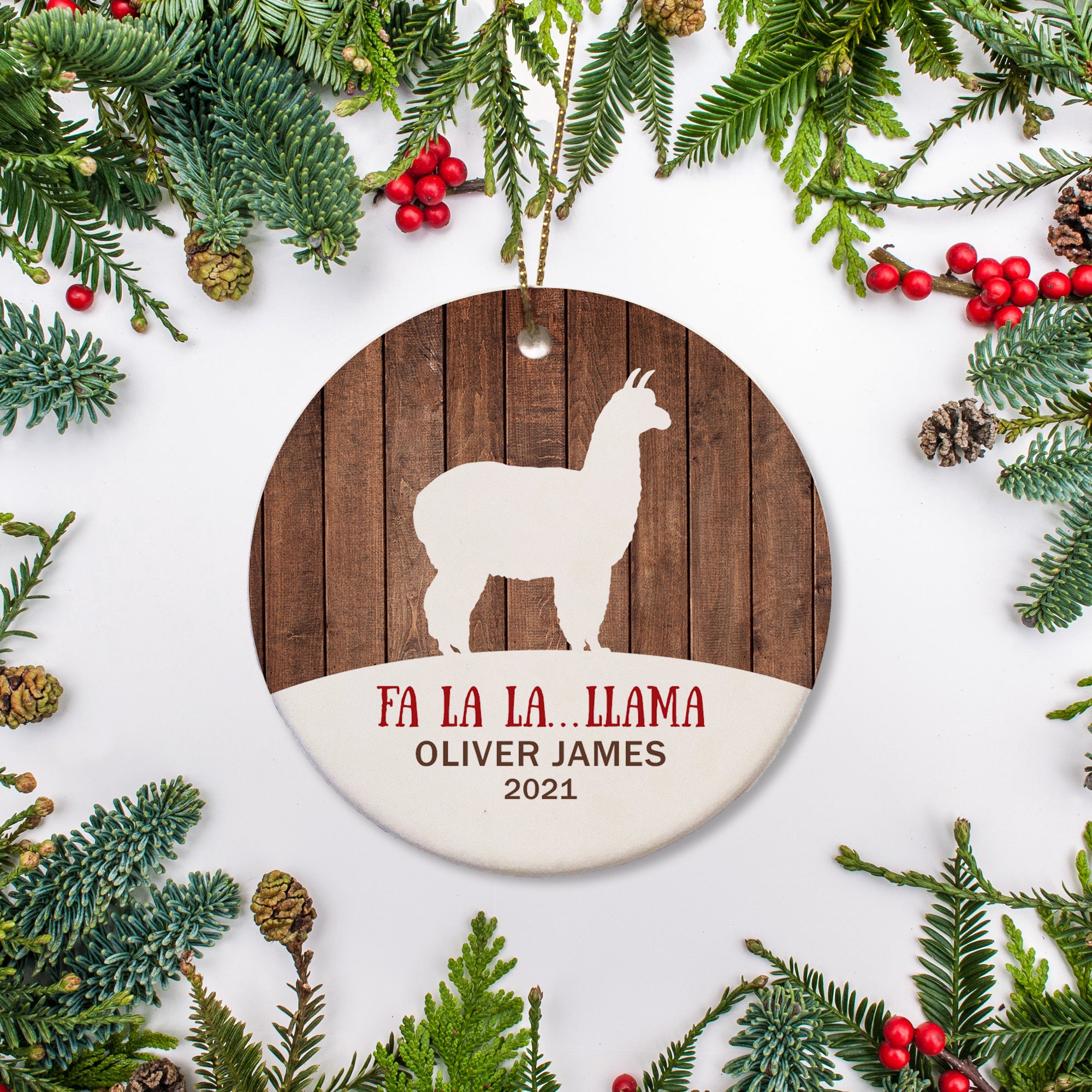 White silhouette of llama standing on a mound of snow. Llama on a wood backdrop. Fa la la...llama. Personalized with name and year of your choice.