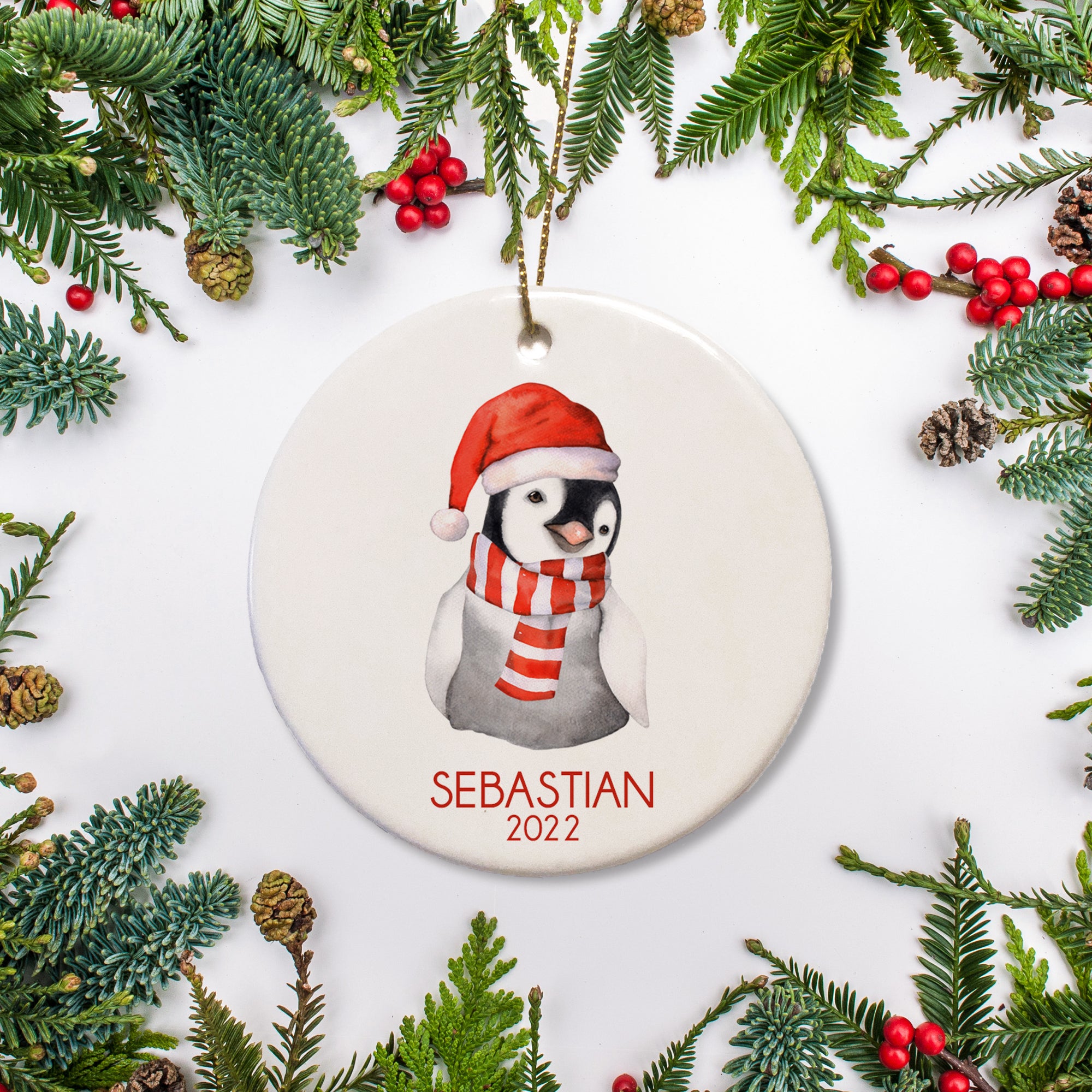 Cute penguin in holiday scarf and hat.  Personalized with name and year, ceramic round Christmas ornament - Pipsy.com