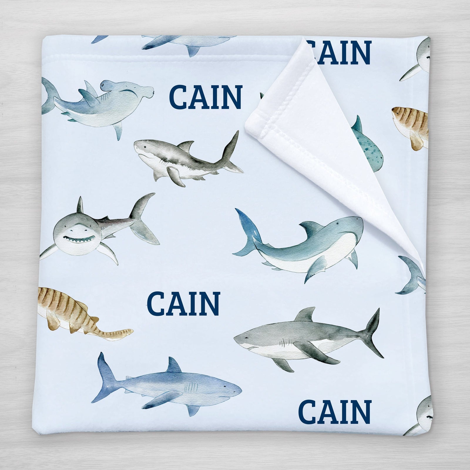 Our personalized shark blanket has your child's name and an assortment of sharks (tiger shark, hammer head shark, whale shark and more). Choose a smaller size for a stroller blanket, or one of our huge sherpa blankets for a snuggle blanket that will be loved for years.