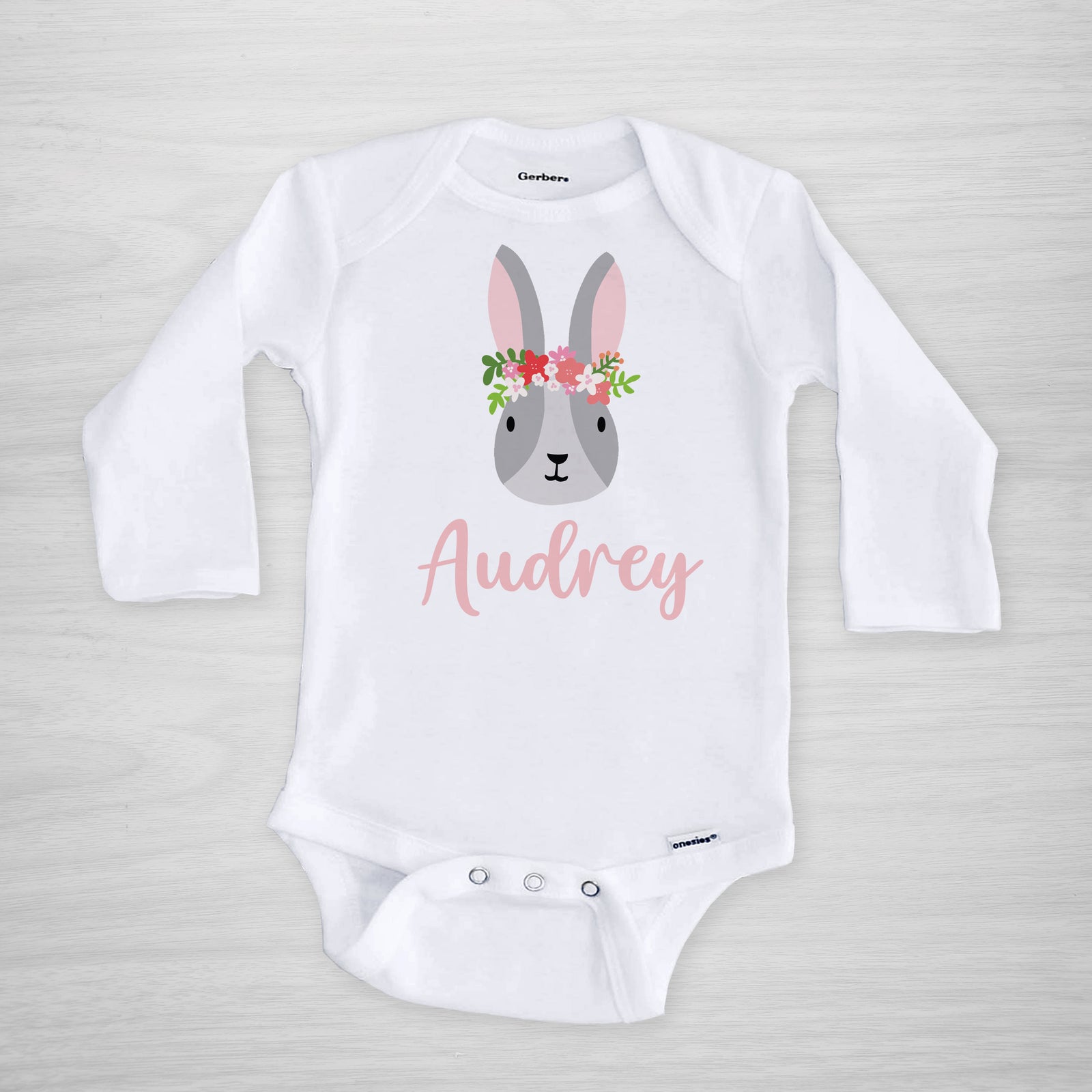 This onesie features a sweet Easter bunny with a crown of flowers, and your little one's name, short sleeved