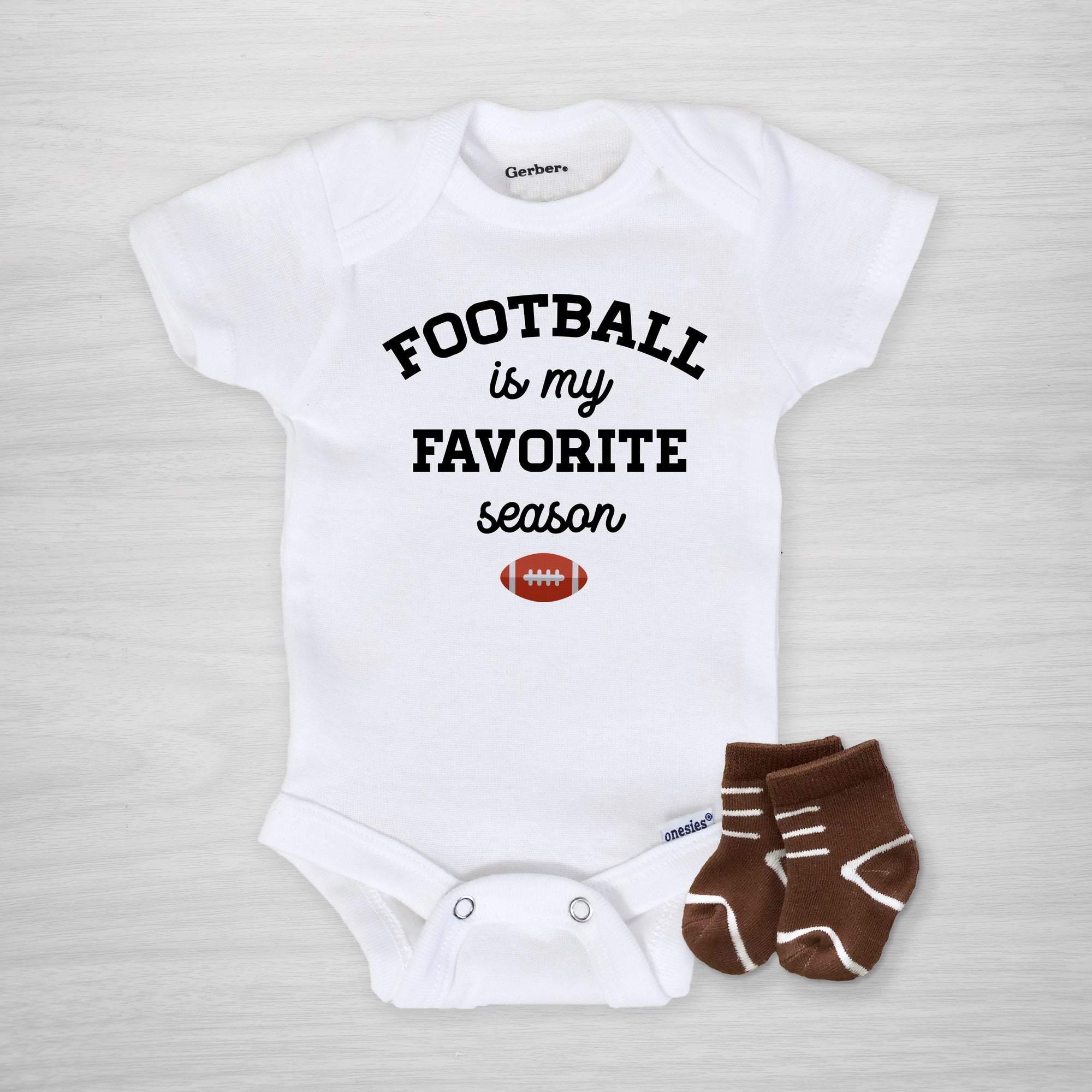 Football is my favorite season Gerber Onesie®. White onesie with black text and football illustration. Text can be changed to your favorite team colors on request, long sleeved, Pipsy.com